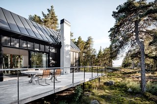 Elevated on steel posts, the central volume and exterior deck project west toward the sea.