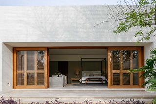 Massive, timber-framed sliding doors connect the master bedroom with the outdoors.