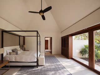 The master bedroom faces walls of glazing that frame tropical views. The bedroom connects to the master bath with a double vanity as well as a spacious walk-in closet in a separate room. The floors are Galala marble.