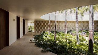 A limestone partition wall screens the indoor courtyard from the garage.