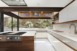  Originally covered in colorful tile, the kitchen received a monochromatic upgrade with white quartz countertops and new state-of-the-art appliances.
