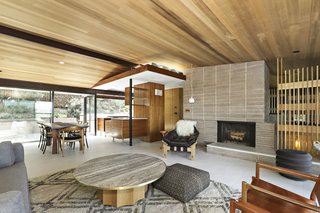 The original floor plan and design elements remain—from the concrete block fireplace to the restored sconces. The vaulted ceiling is made from western red cedar.