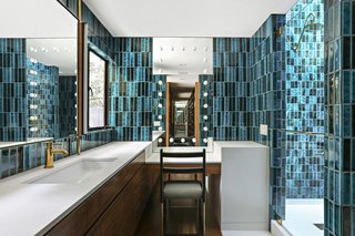 The master bath is covered in vibrantly colored tile.