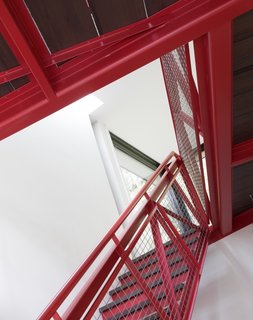 Painted a vibrant red (Benjamin Moore Chili Pepper 2004-20), the stairs offer a playful splash of color against the white walls.
