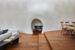 The white plaster inside the home signals a continuation of the outdoor facade. The cave-like nook was inspired by the fireplace in Swedish architect Erik Gunnar Asplund's summer house.