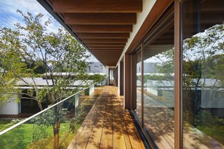 A covered outdoor walkway connects the three upstairs bedrooms and overlooks views of the courtyard.