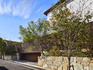 A ramp beneath the lath screen leads to a two-car garage hidden under the inner courtyard's grassy knoll.