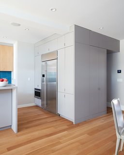 The kitchen also contains a custom casework "cube" that conceals appliances and a hidden powder room.