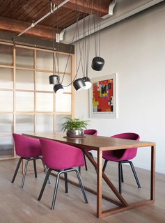 Flos lighting hangs over a BluDot dining room table with Hay dining chairs.