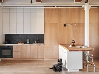 "Since the kitchen is open to the space, we tried to make it look as clean as possible with slab-faced cabinets flush to the walls, simple tile, and clean appliances," Shively says. The island is inspired by Alvar Alto's designs.