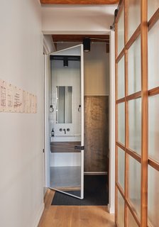 A full-length mirror on one side of the 10-foot-tall door brings additional light into the bathroom.