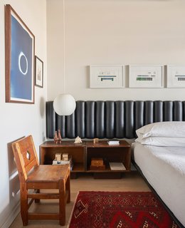 A tufted leather headboard with deep channels adds textural interest to the bedroom.