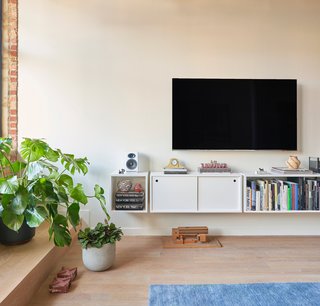 The walls are painted Benjamin Moore Silver Satin. Floating bookshelves help reduce visual clutter.