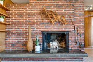 A masonry core at the heart of the home features a cantilevered, polished concrete hearth that has naturally darkened with age.