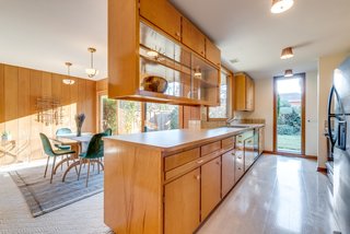 The kitchen is outfitted with birch cabinetry and a pull-out breakfast bar.