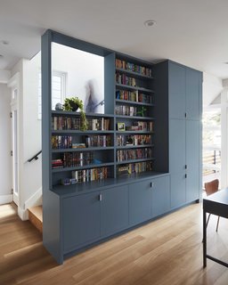 Reveals and windows built into the unit help bring the cabinet down to a more human scale, while hidden panels provide functionality with minimal visual clutter.