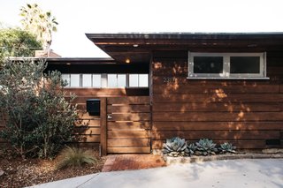 The midcentury home is clad in horizontal planks of redwood.