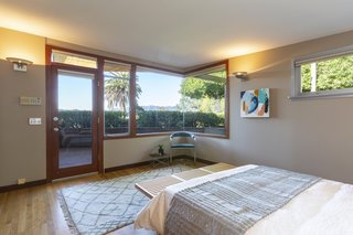 The master bedroom opens up to a triangular outdoor deck. The corner window lets in light and panoramic mountain views.