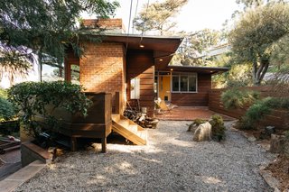 A northeast-facing view of the home's front entrance and brick patio.