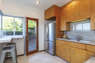 The kitchen, fitted with maple cabinetry, opens up to a redwood deck that connects to the master bedroom.