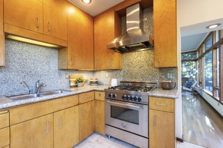 The backsplash and countertops are made from granite. Terrazzo marble lines the kitchen floor.