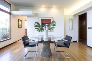 A door separates the open-plan living and dining area from the entry hall. White oak flooring is used throughout the home.