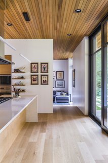 A view from the kitchen to the study on the south side of the house. White oak hardwood floors feature throughout, while the ceiling is tongue-and-groove cedar.