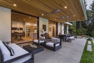 Indoor/outdoor living is emphasized throughout the design. Pictured is the protected terrace with Restoration Hardware seating, a Marbella Metal Rectangular table, and acid-washed concrete flooring.