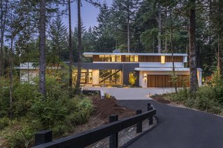 A true "forested retreat," the home is accessed via a private entry road through the woods.