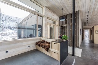 The exposed concrete floors, also equipped with radiant heating, help passively cool and heat the home in summer and winter, respectively. The bridge leading to the guest wing can be seen to the right of the mudroom.