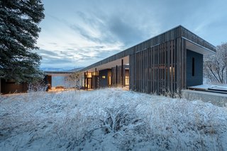 The angled roof mimics the sloped terrain and connects the cedar-lined sauna (on the right) to the main house and garage.