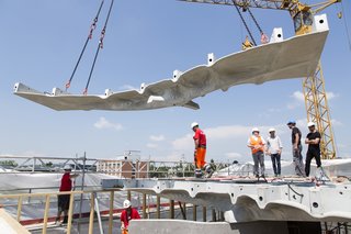 The team installs a 2.5-tonne section of Smart Slab, built from glass fiber-reinforced concrete sprayed onto a 3D-printed formwork.