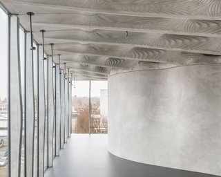 Fifteen bespoke, digitally fabricated concrete mullions made with Smart Dynamic Casting line the facade. The free-form Mesh Mould wall supports the weight of the Smart Slab ceiling.