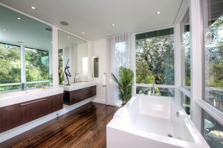 The master bath includes double vanities, a freestanding bathtub, and a hidden built-in television.