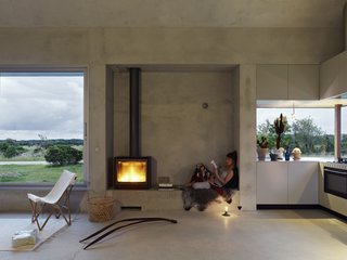 To minimize the home's energy footprint, the floor and foundation are made from cast concrete. Large openings allow for natural ventilation, while surrounding trees help create a cool microclimate. The house is powered by geothermal energy.
