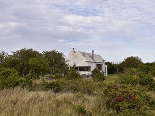 Located on the Swedish island of Gotland, the house is designed to look like a large boulder to blend in with the landscape. "It is a stone among other stones," the designers say.