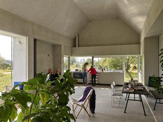 In contrast to the home's "heavy" appearance, the interior feels light and airy. Large panes of glass frame views of a secret garden to the north and a clearing for events to the south.