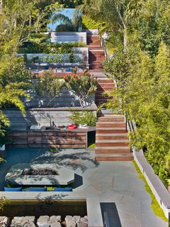 Plants were snuck into every possible corner to soften, create ambience, and screen the city vibes. Outside the great room, the custom-cut geometric natural stone patio and fire pit table draws you into the outdoor kitchen and lounge. 