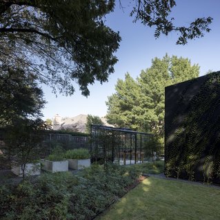 Sited on a wooded lot across from the Texas Parks and Wildlife Department, this contemporary residence by 5G Studio Collaborative blurs the boundaries between indoors and outdoors with plenty of glass walls, a large garden, and a greenhouse. 