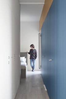 With the sliding mirrored door open, the corridor allows light from the bedroom to suffuse the entire space.