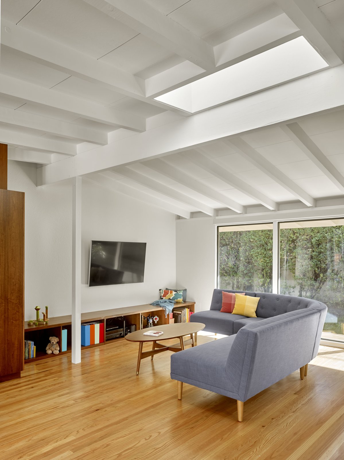 Custom walnut built-ins offer storage and reduce the need for furniture. Full height windows open onto large, level decks creating a strong indoor-outdoor