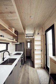 The tall ladder lives secured against the wall, but can be attached to either the guest loft or storage soffit, providing access to either.