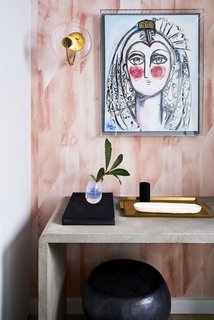 Modern entrance art and framing with a modern sconce and wallpaper.