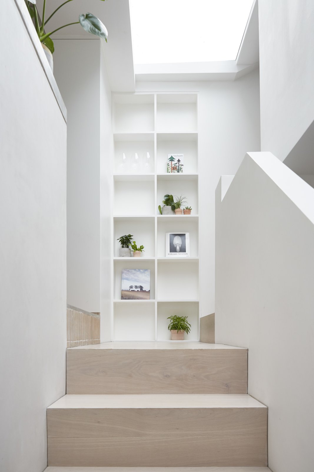 A new stair to the kitchen is clad in oak, and natural light floods in from the roof light above