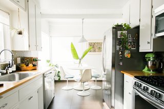 The breakfast area features vintage chairs and an Ikea table — a classic high-low mix.