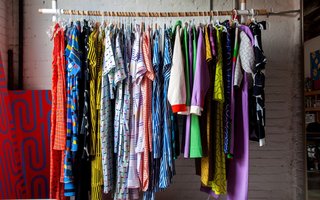 Dozens of examples of her brightly colored graphic prints are on display in some form — a rack of silky dresses, linen jumpsuits, and color-blocked jackets from her spring collection greet guests as soon as they walk in; a stack of dog beds, usually occupied by her Boston terrier, Snips, is in one corner, across from a pile of patterned and embroidered throw pillows; shelves are stacked with graphic bath and beach towels, fruit-printed bed linens and cozy blankets; poster boards of some of her most loved prints are both hung and leaning against any available wall space.