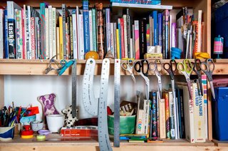 There's a sense of organization amidst the madness. A collection of scissors hang from nails hammered into a shelf packed with books seemingly arranged in no particular order — that is, until Van Dusen hardly glances when she pulls one, The Penguin Dictionary of Curious and Interesting Geometry, within seconds of referencing it.