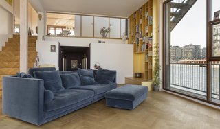 High ceilings, an open staircase, and fitted cabinetry are some of the space-enhancing features in the living room.