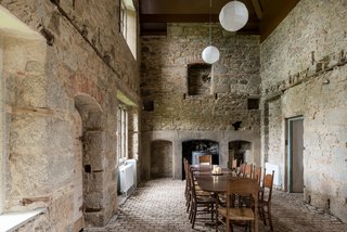 The most dramatic room in the main house is the dining room, which features a soaring, pitched ceiling and exposed stone walls.