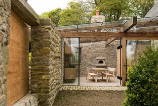 The kitchen, the property's only modern addition, has been created from a garden courtyard. The space has been enclosed by a glazed roof and wall with sliding door, yet it retains its open feel.